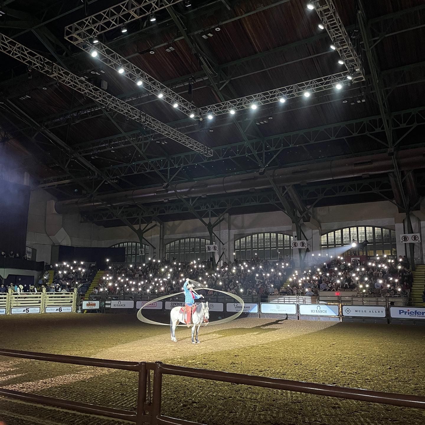 a man is riding a horse in a large arena
