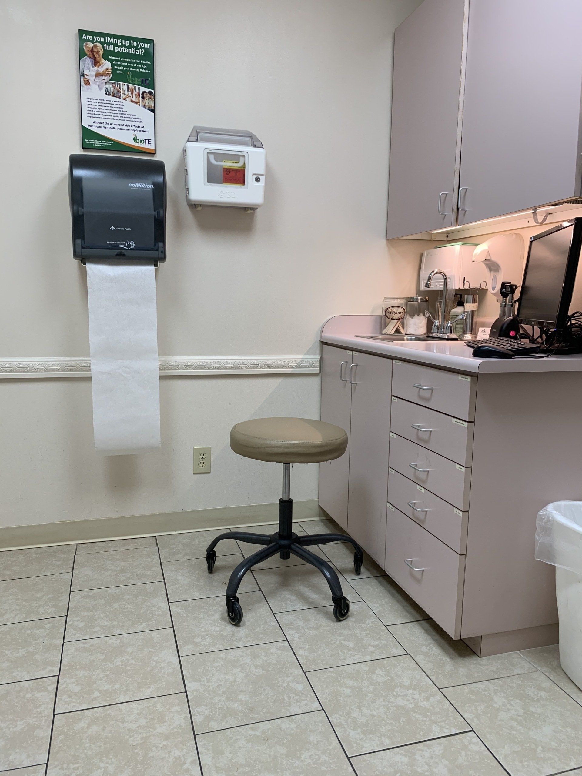 a doctor 's office with a stool and a computer