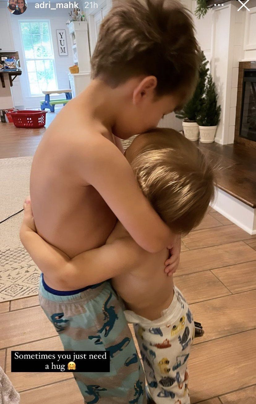 two little brothers are holding each other in a hug
