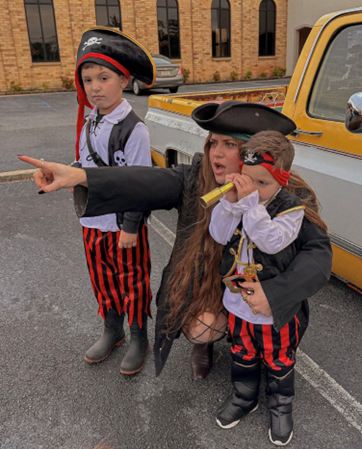 a woman in a pirate costume is pointing at something