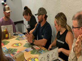a group of people are sitting around a table with a menu on it