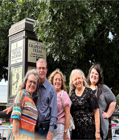 a group of people standing in front of a sign that says grafevine texas