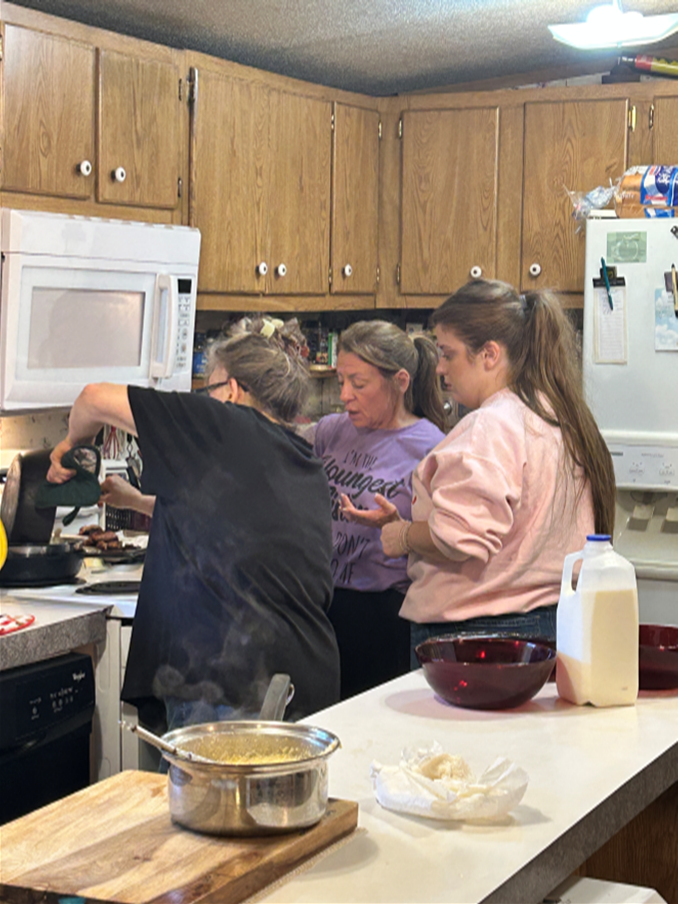 ladies cooking and pouring up from a cooked pot