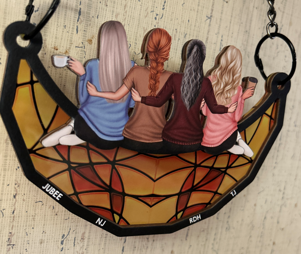 stained glass picture of 4 ladies with arms around each other. names are attached