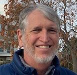 grinning man with pretty fall foliage behind him
