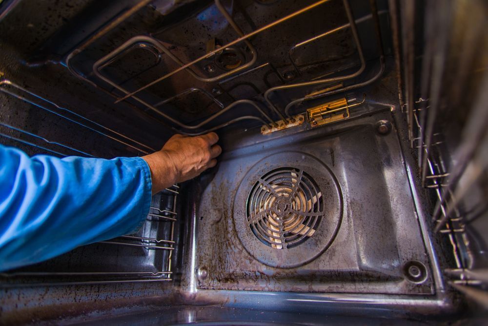 A person is cleaning the inside of an oven.