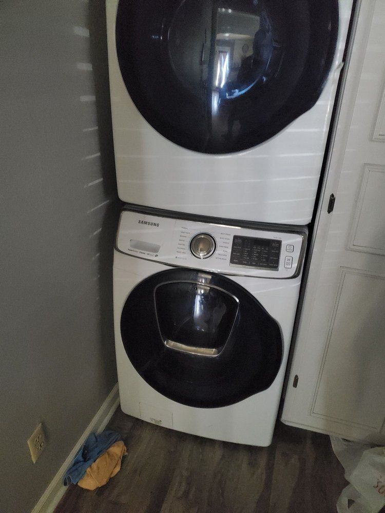 A washer and dryer are stacked on top of each other in a laundry room.