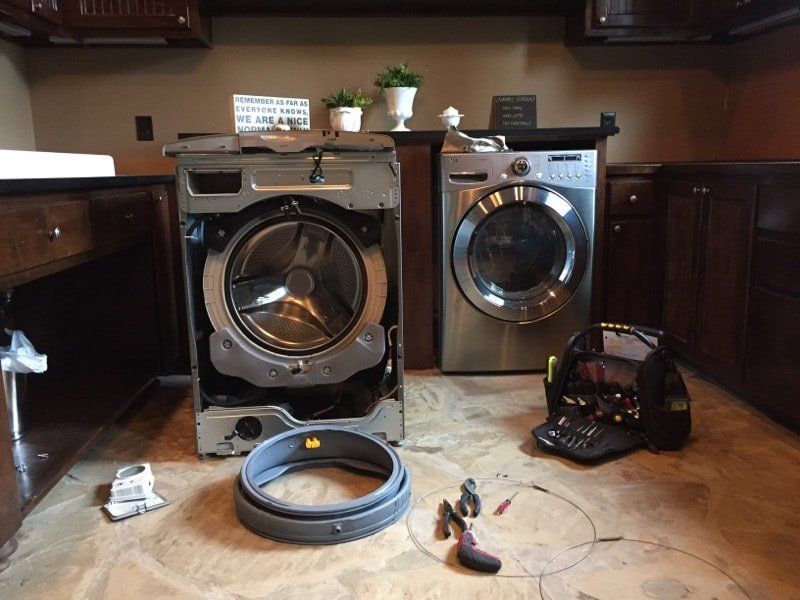 A washer and dryer are sitting on the floor in a laundry room.
