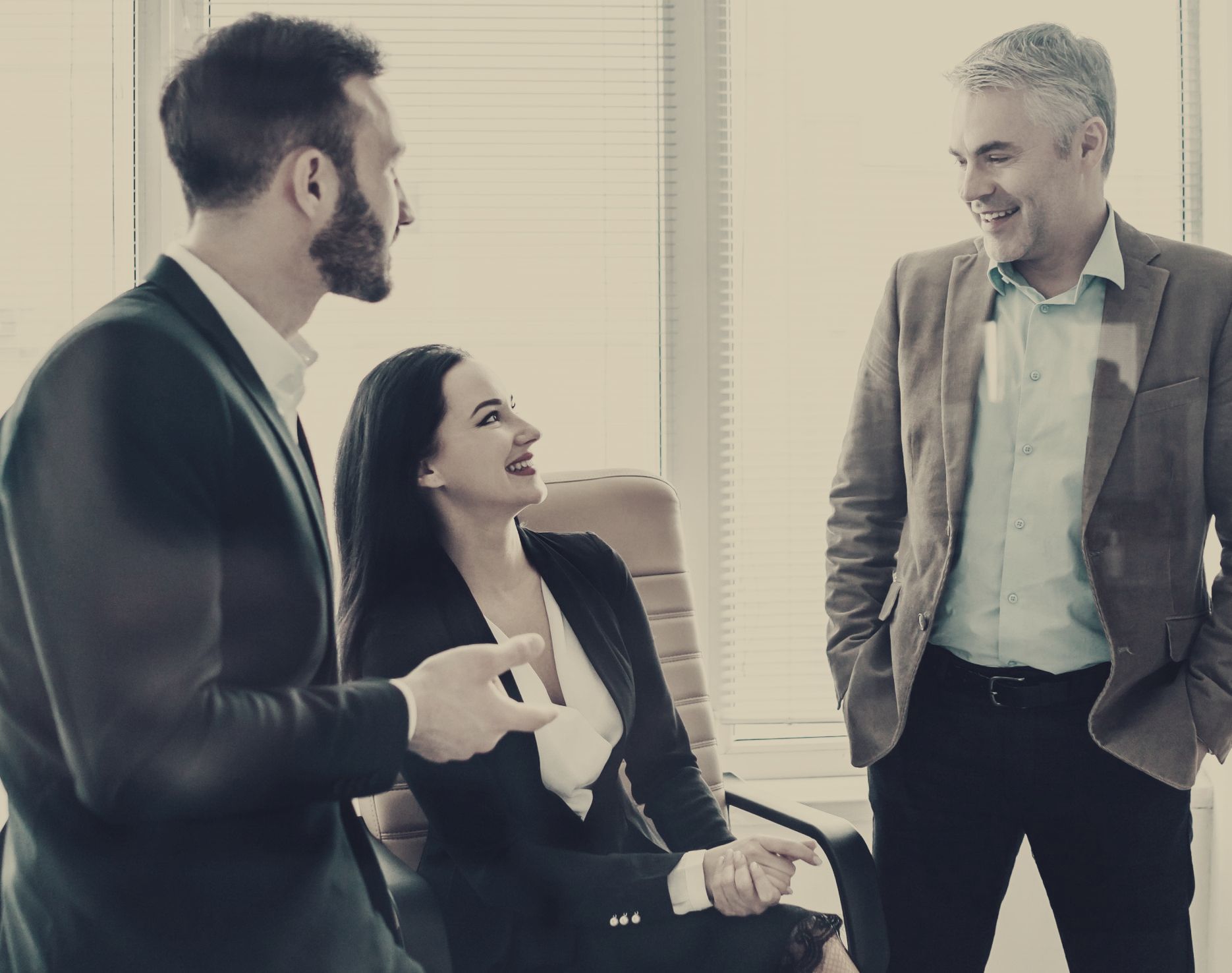 A group of business people are having a conversation in an office.