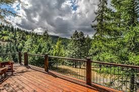 A wooden deck with a view of a forest and mountains.