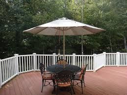 There is a table and chairs on the deck with an umbrella.