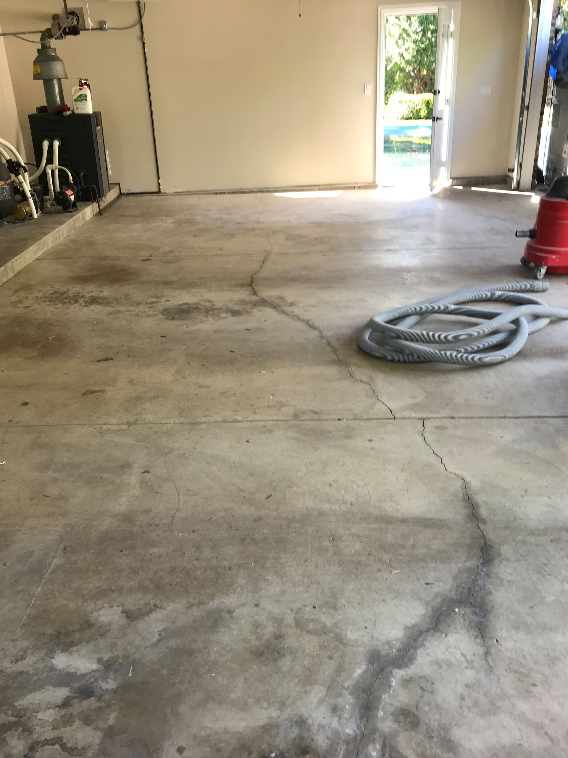 A vacuum cleaner is sitting on the floor of a garage