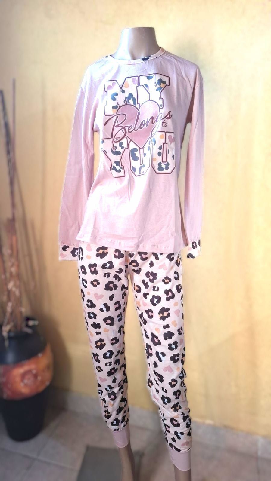 Un maniquí lleva un conjunto de pijama rosa con pantalones con estampado de leopardo.