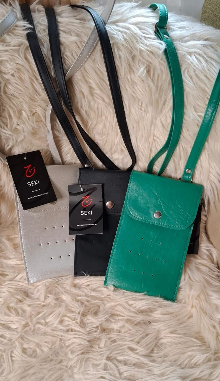 Tres bolsos están colocados encima de una manta peluda.