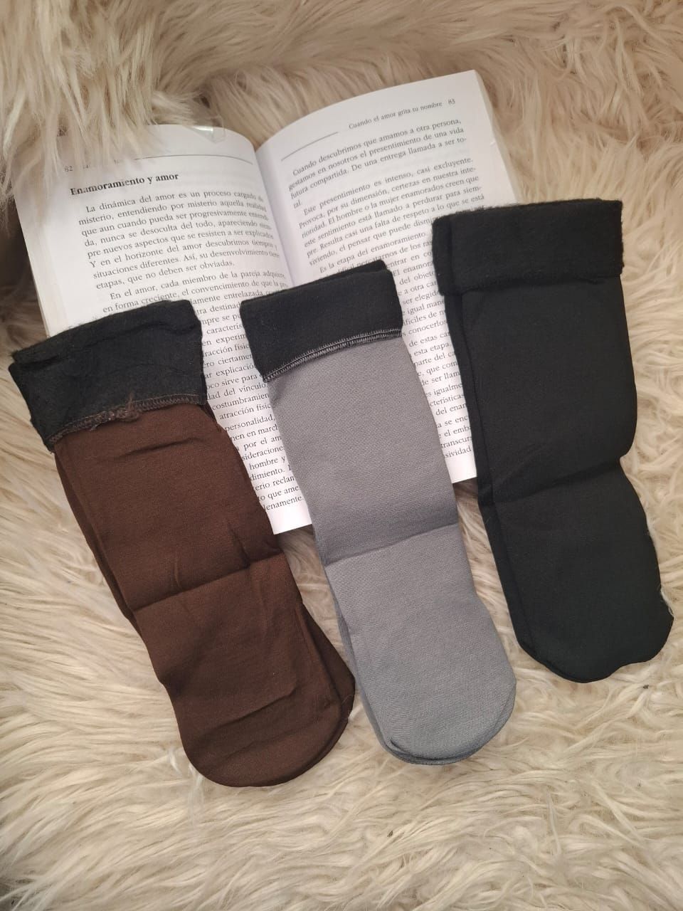 Tres pares de calcetines están encima de un libro abierto.