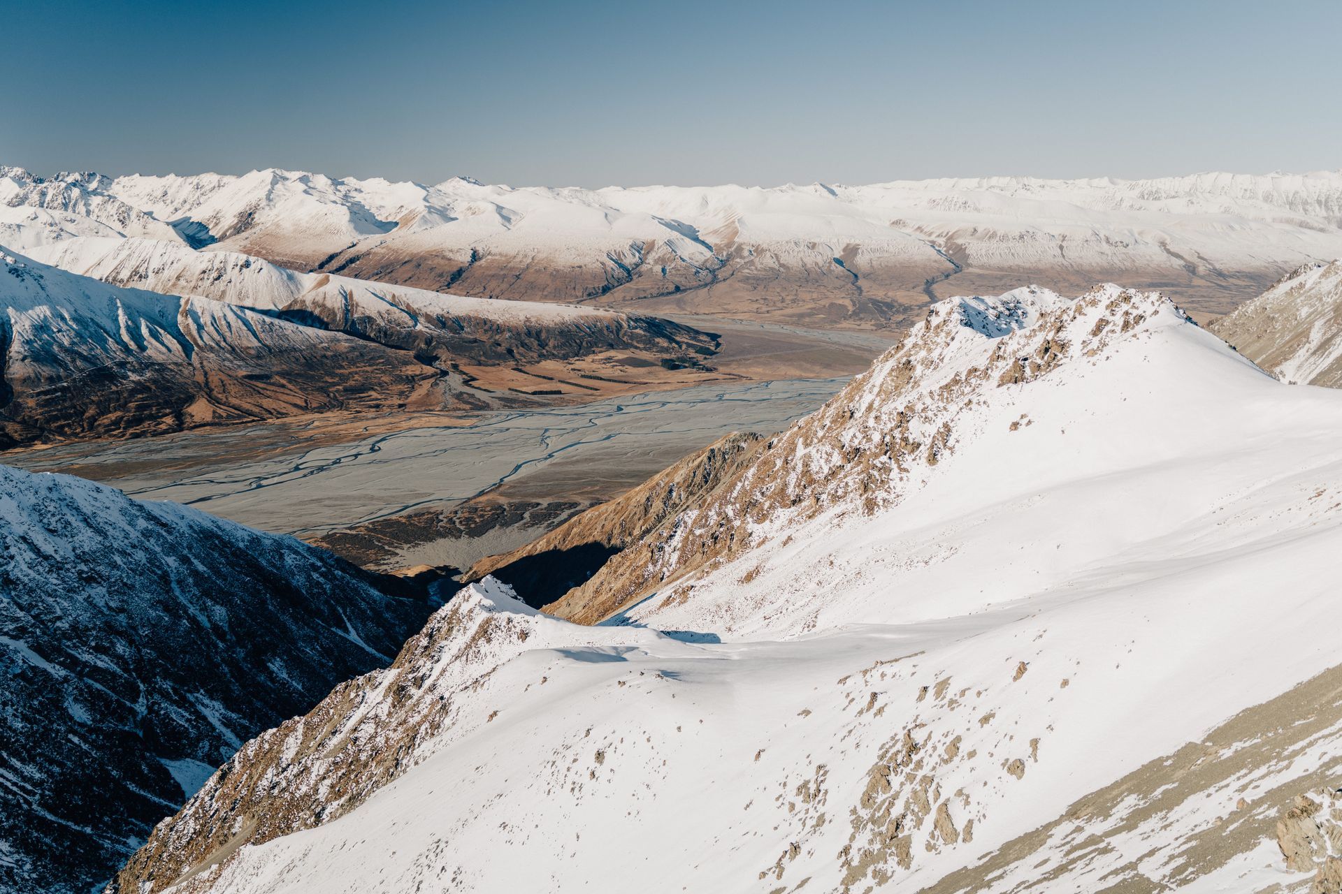 A snowy mountain range with a lake in the middle of it