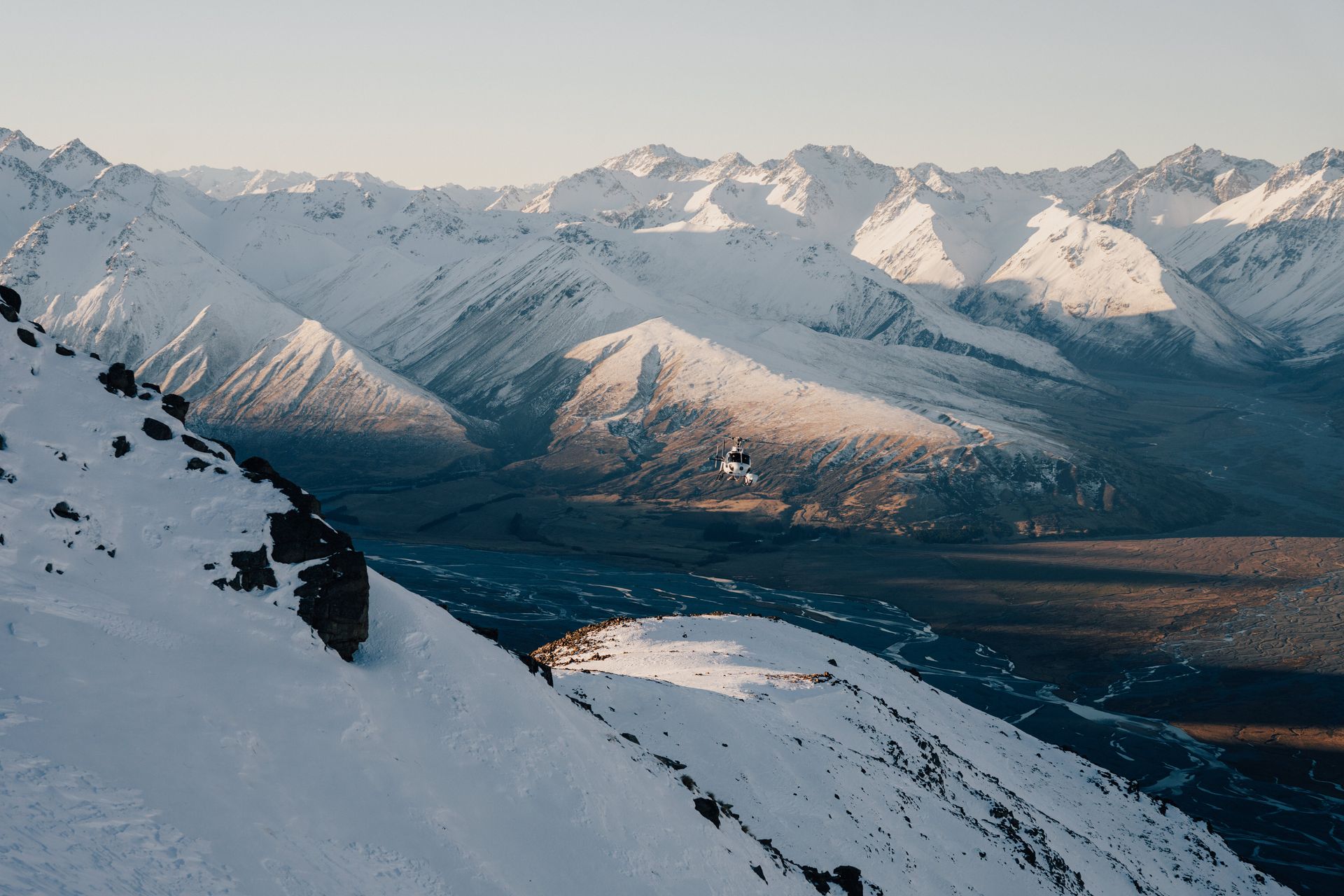 A snowy mountain range with a city in the distance