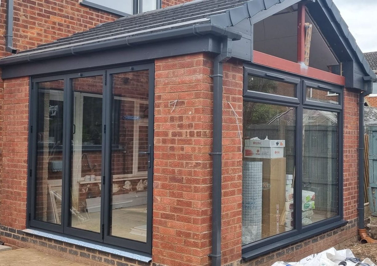 Brick extension with black-framed windows, red brick, and a dark roof.