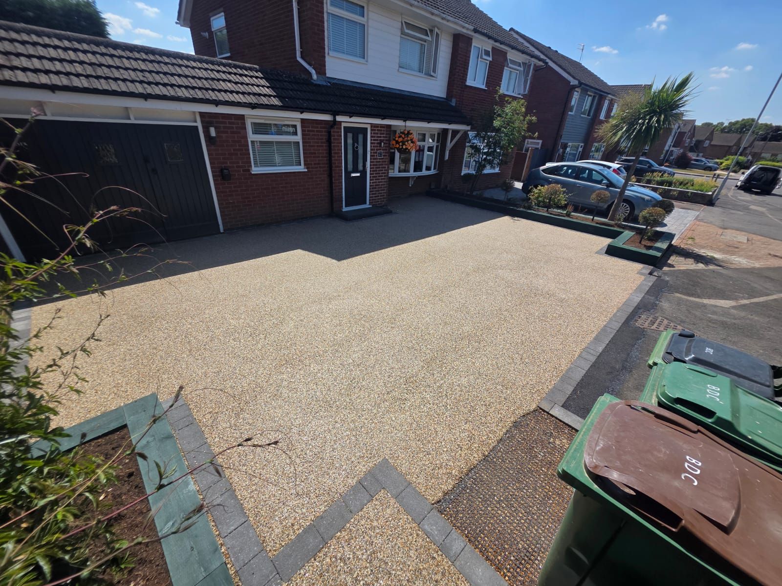Driveway with beige gravel and brickwork in front of a brick house resin driveway