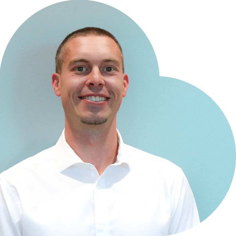 Man in a white shirt smiles, set against a blue heart-shaped background.