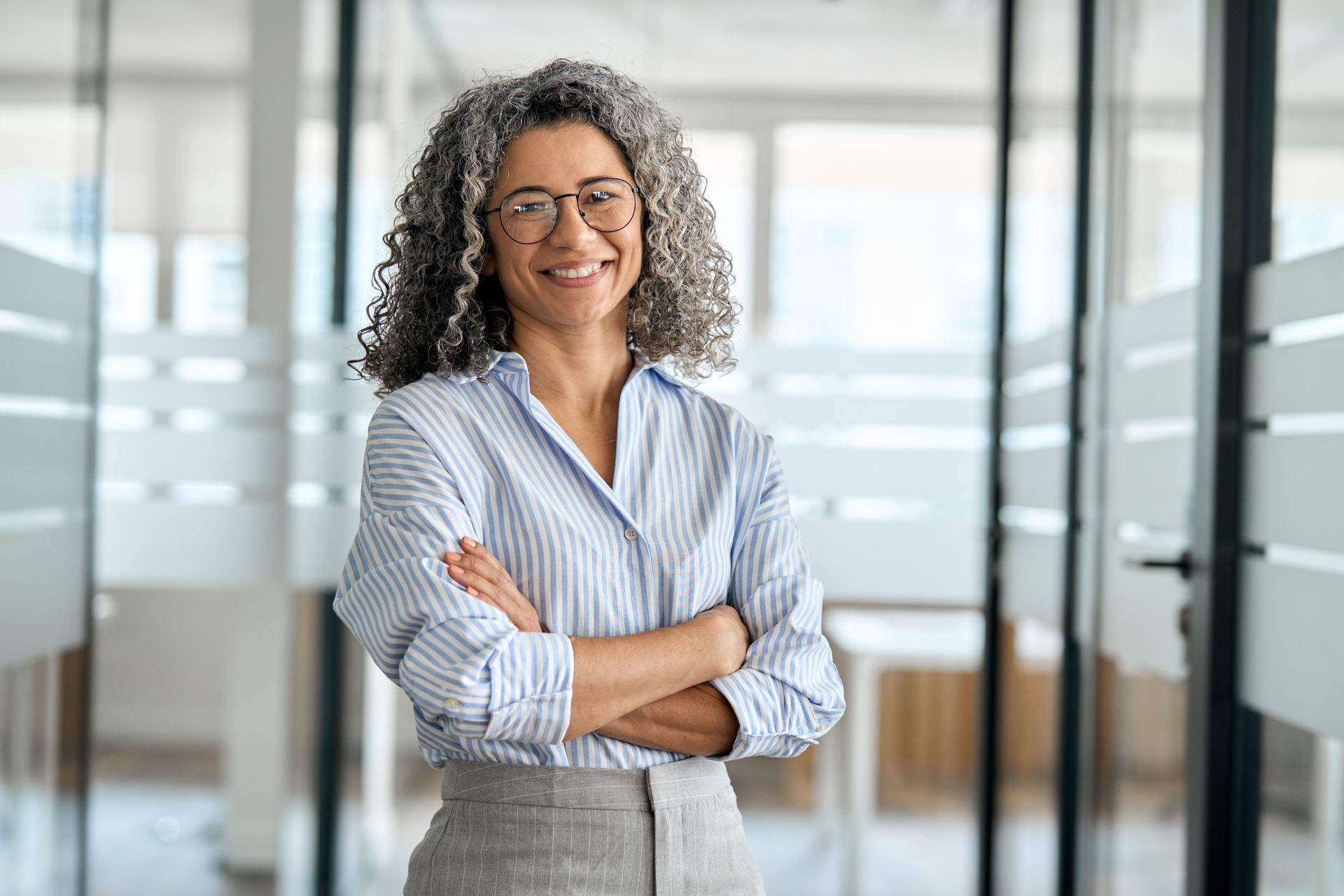 A woman is sitting at a desk talking to another woman.