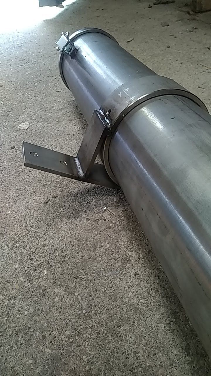 Un tuyau métallique est posé sur un sol en béton.