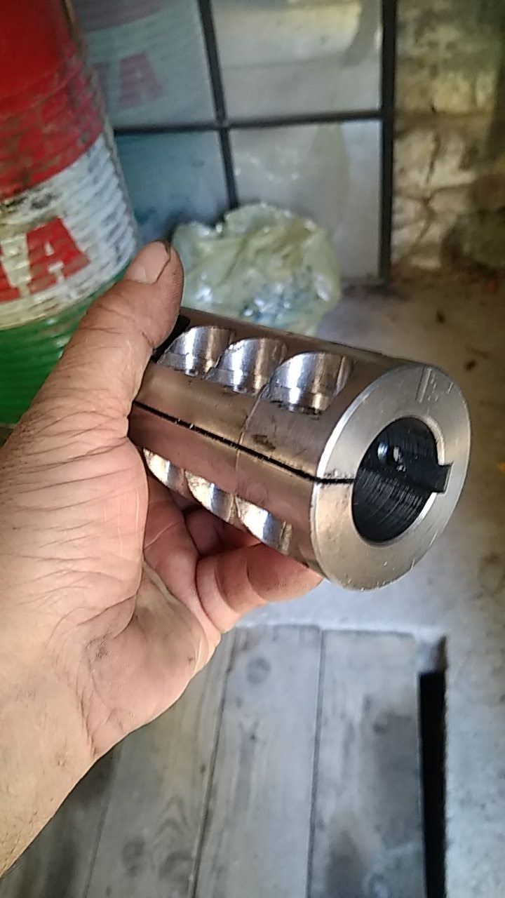 Une personne tient un objet en métal dans sa main.