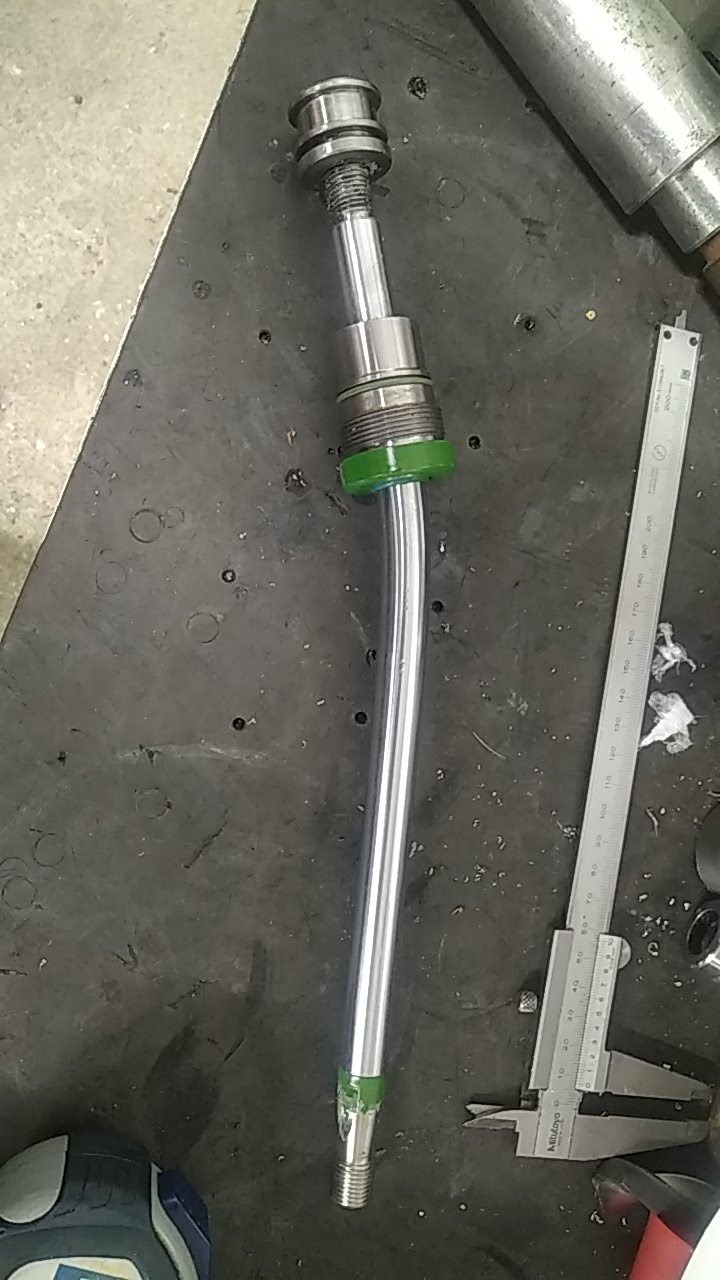 Une tige métallique est posée sur une table à côté d'une règle.