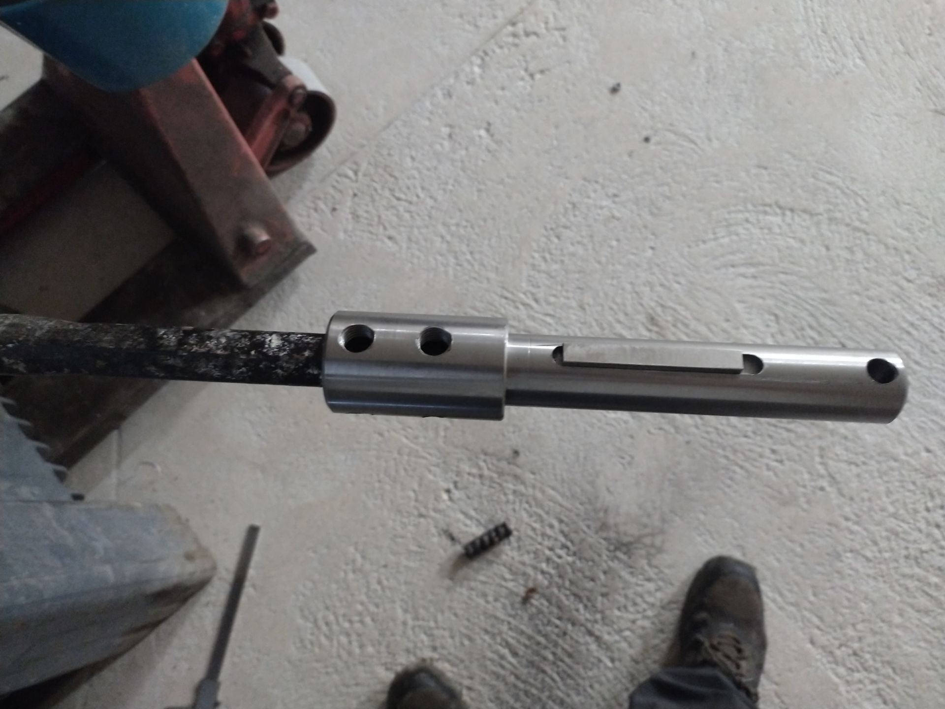 Une personne se tient à côté d'un morceau de métal sur le sol.