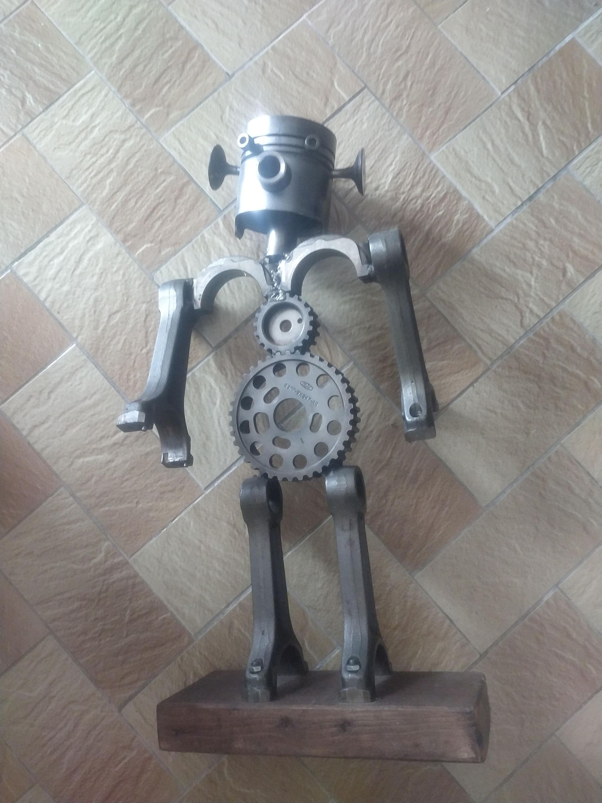 Une statue d'un robot faite de pistons et d'engrenages