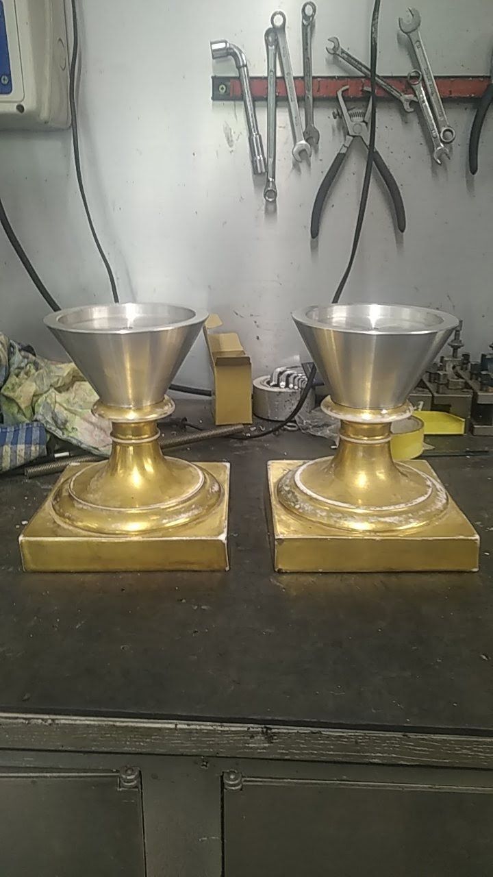 Une paire de vases en laiton posés sur une table.