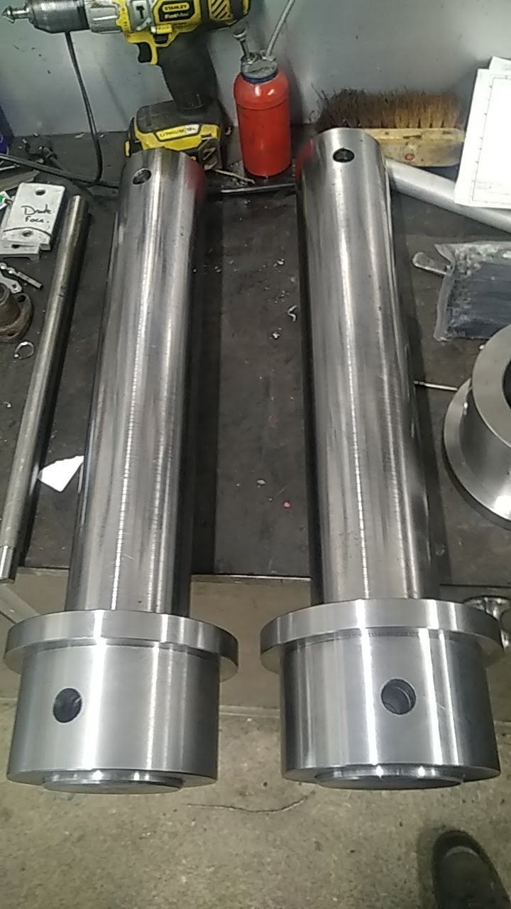 Deux tuyaux métalliques sont posés sur une table à côté d'un extincteur.