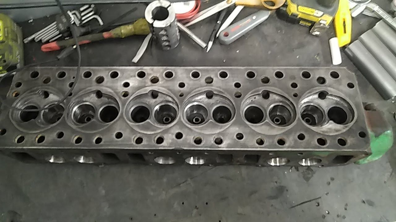 Une culasse est posée sur une table à côté d'outils.