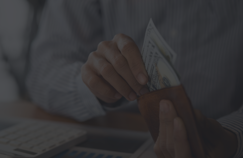 A person is taking money out of their wallet. | Emerald Automotive