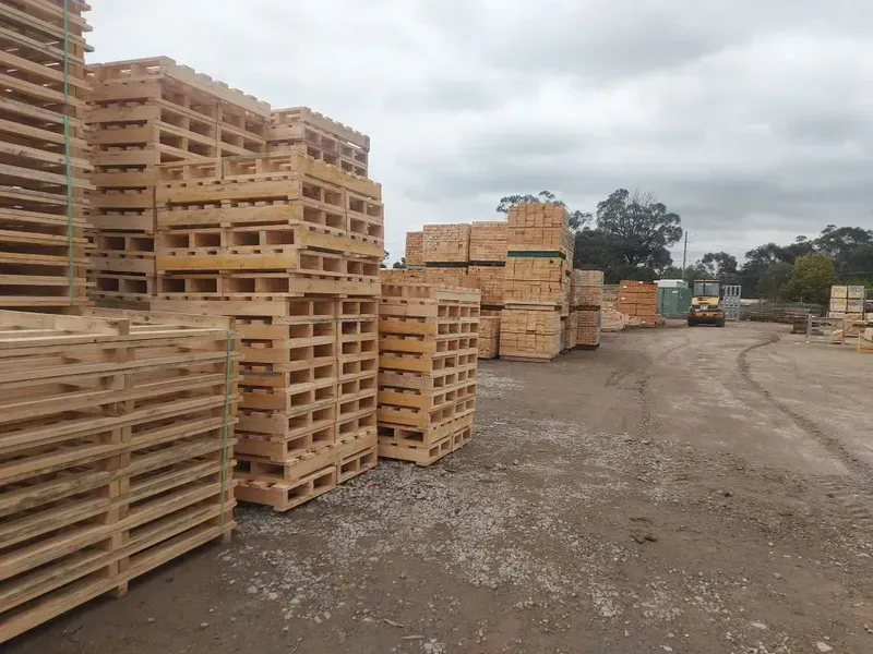 Stacks of Wooden Pallets in An Outdoor Lot on A Cloudy Day — DGW Wholesale Timber & Hardware in Cessnock, NSW