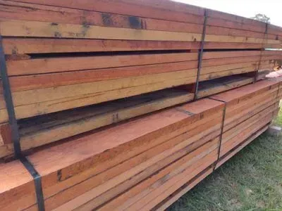Stacks of Wooden Shipping Pallets Outdoors Against a White Wall — DGW Wholesale Timber & Hardware in Rutherford, NSW