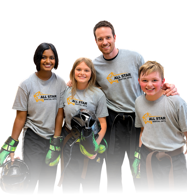 Man pointing, smiling, wearing black hoodie; arm tattoo visible.