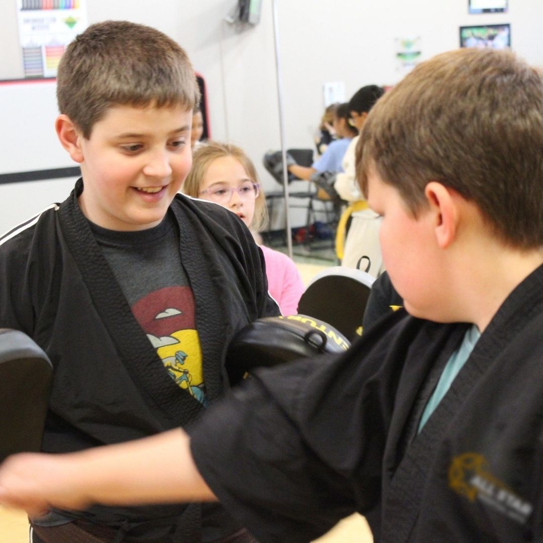 Four men in athletic gear, posing for a photo in a gym.