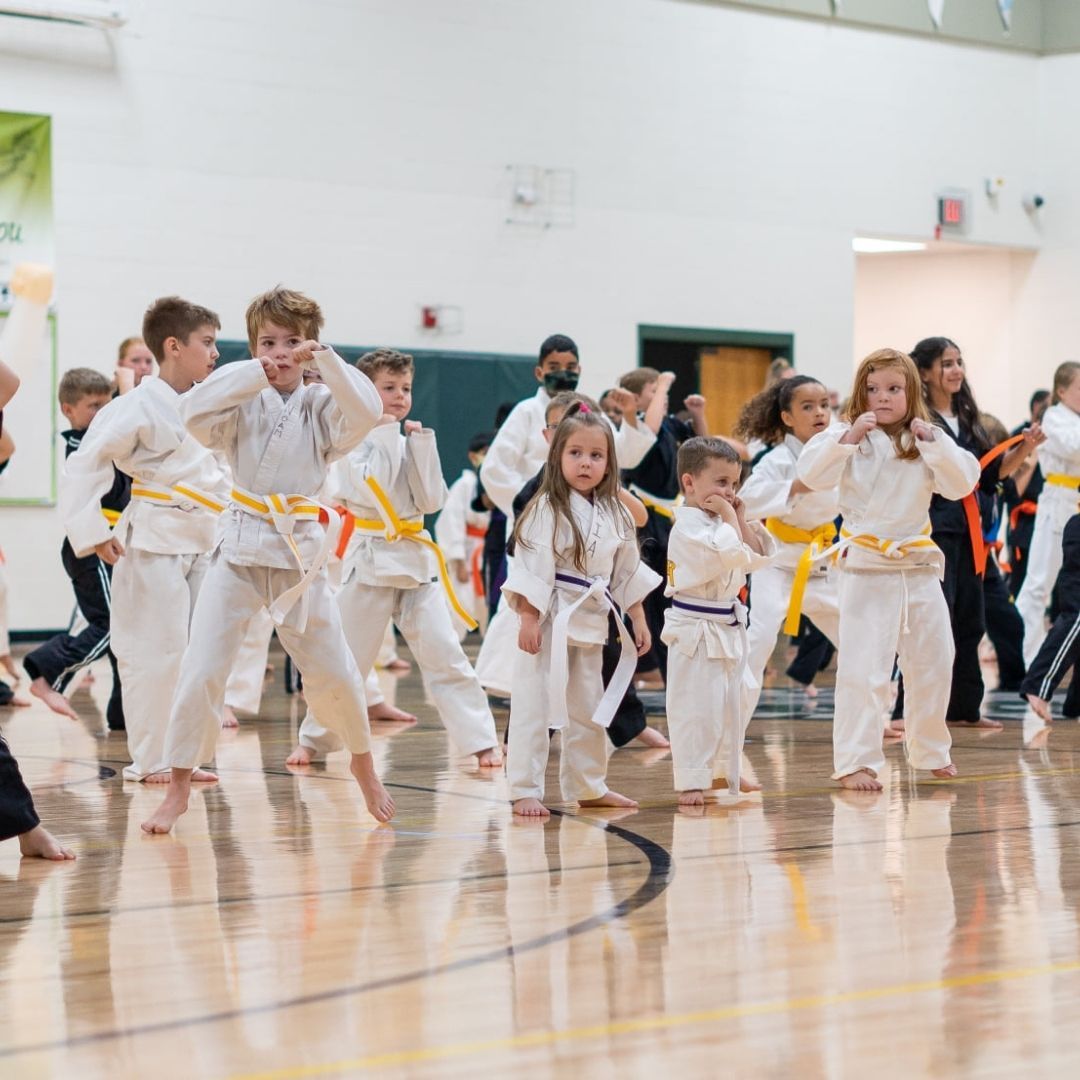 Two men grappling on a mat, one in blue, the other in black.