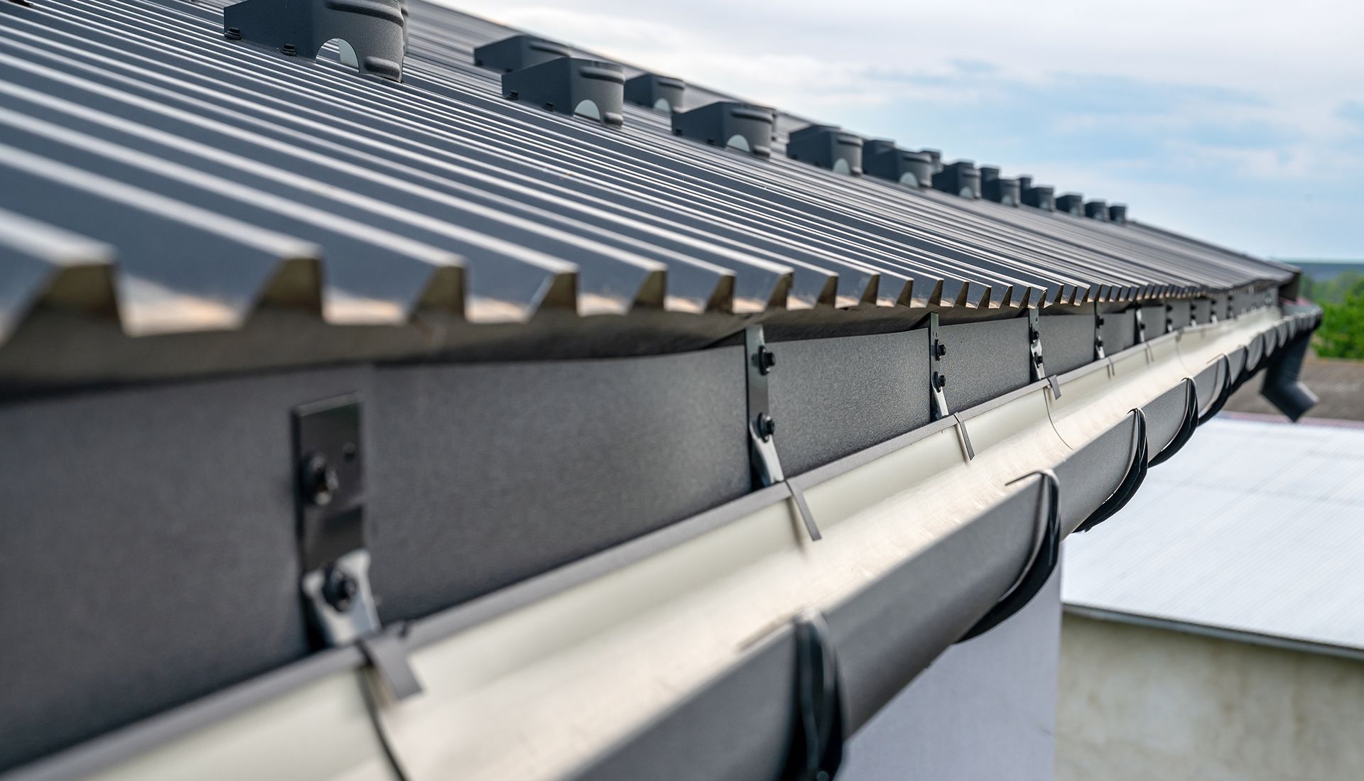 A close up of a gutter on the roof of a building.