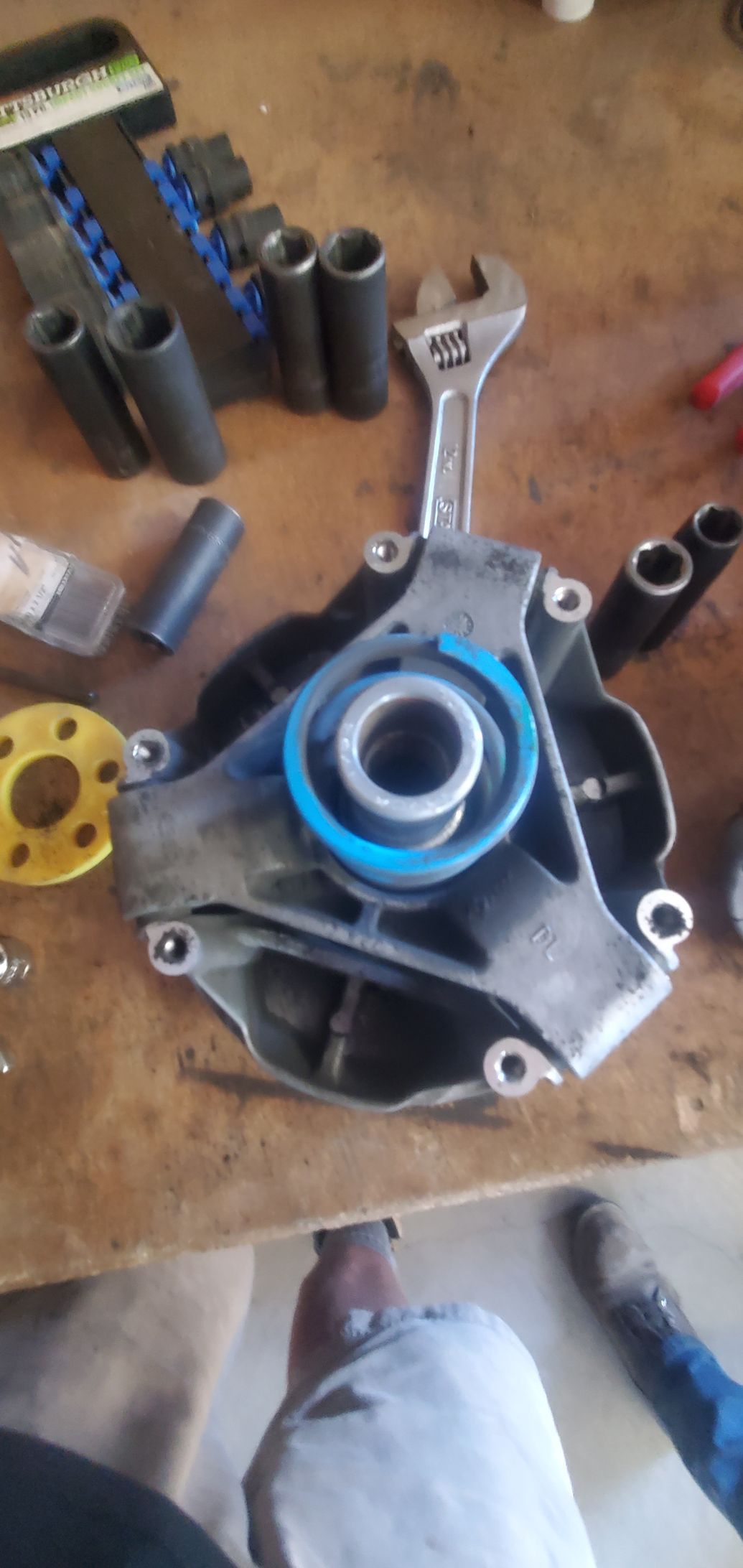 a wrench is sitting on top of a piece of metal on a wooden table .