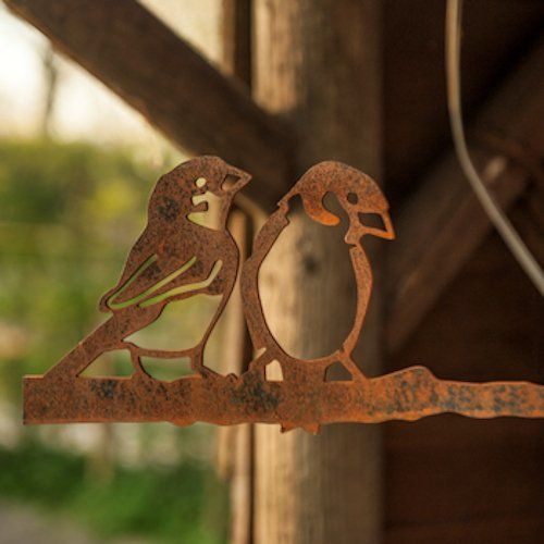 Twee vogels zijn uit een roestig stuk metaal gesneden