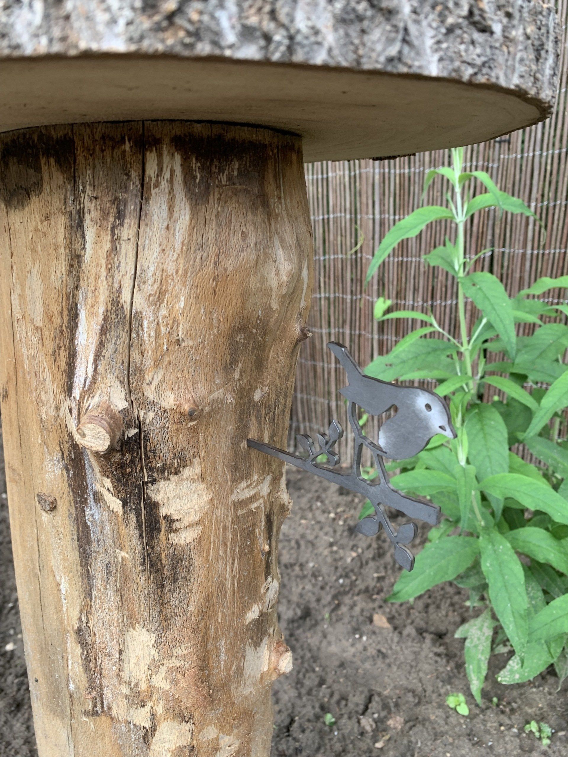 Een voederhuisje gemaakt van een boomstronk in een tuin.