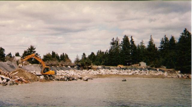 Shoreline Seawalls — Seawall And Yellow Excavator in Thomaston, ME