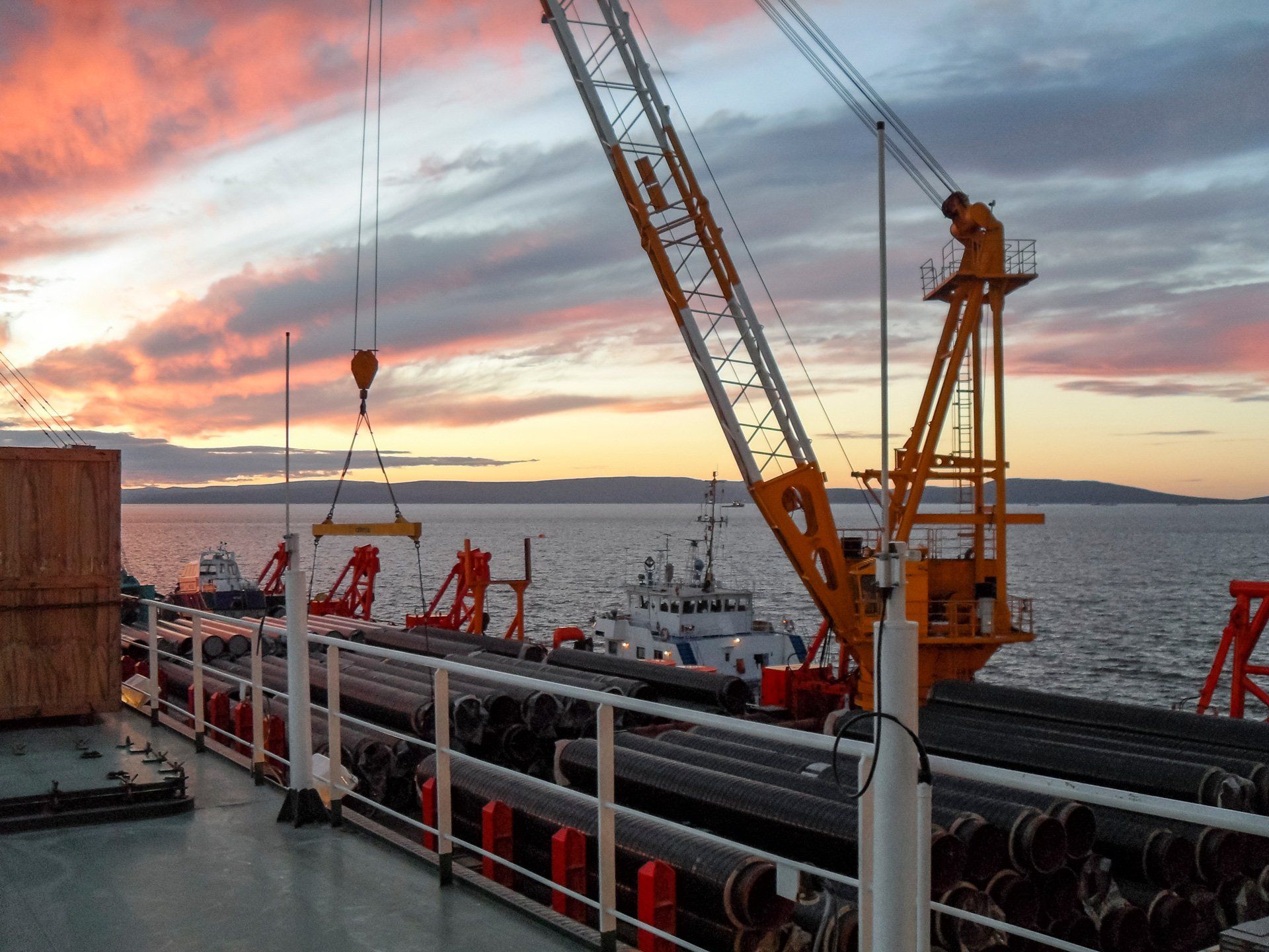 Marine Crane Services — Yellow Crane And Huge Iron Tubes in Thomaston, ME