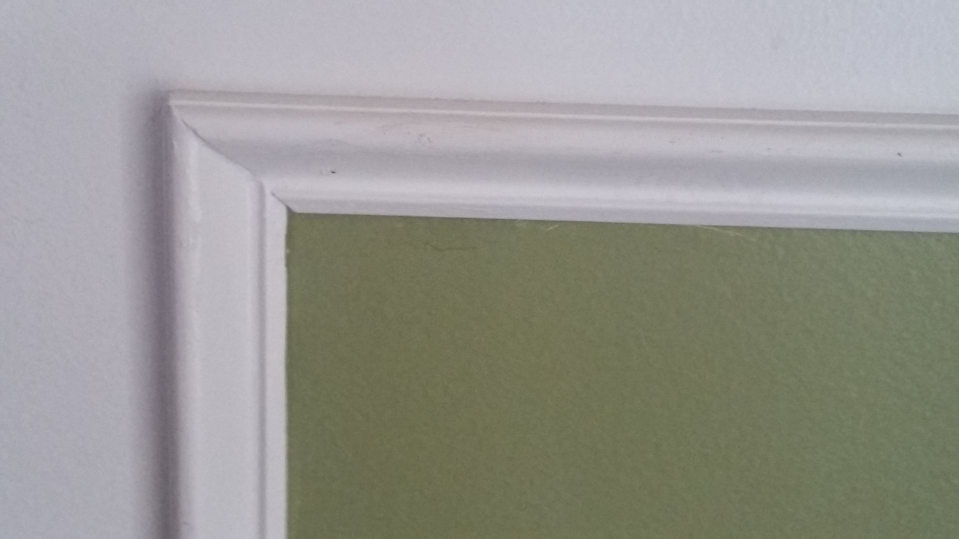 White molding around a green painted wall.