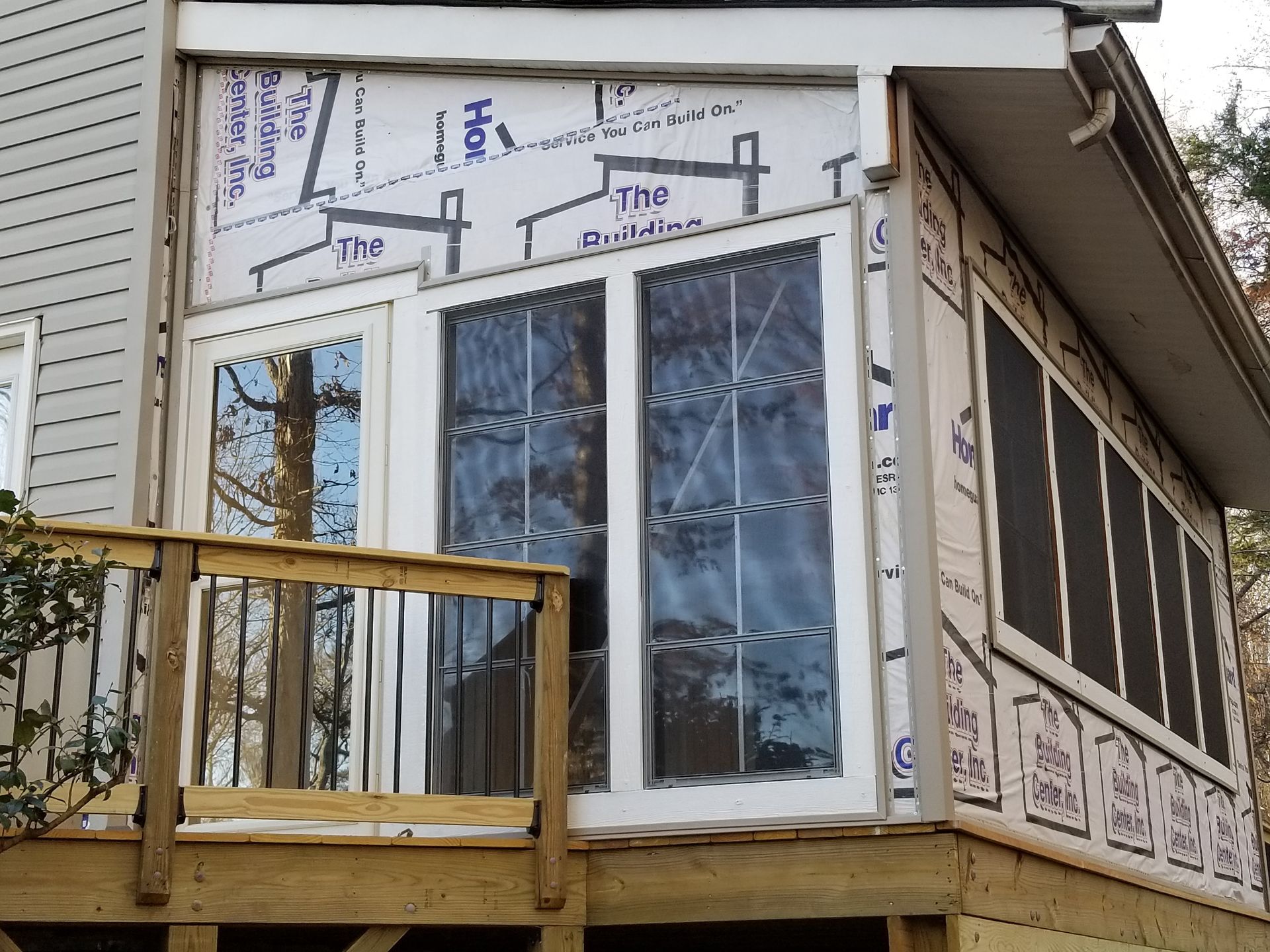 Screened porch addition on a deck, with windows and siding in progress.