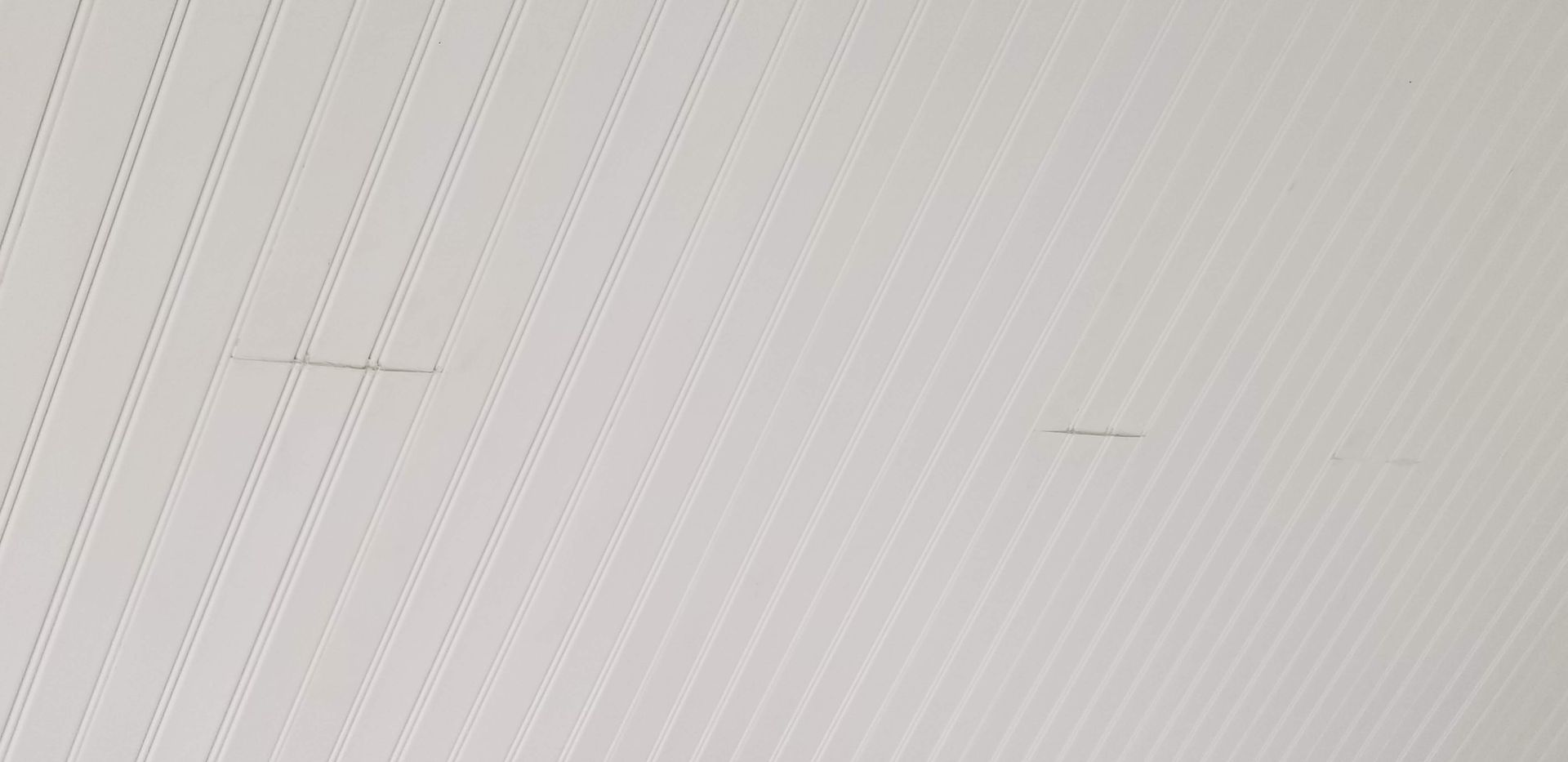 White textured surface with two faint dark marks.