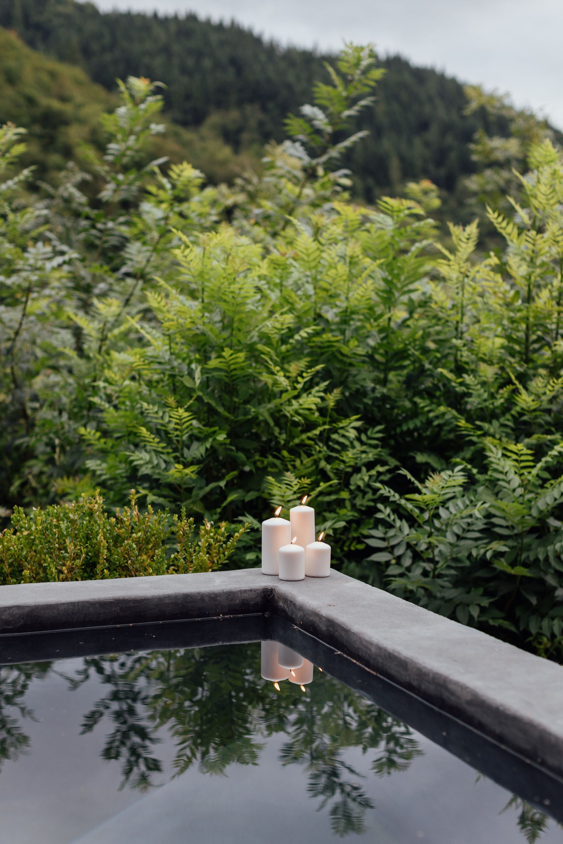 Corner of the outdoor jacuzzi, with lit candles. Completely surrounded by native vegetation.