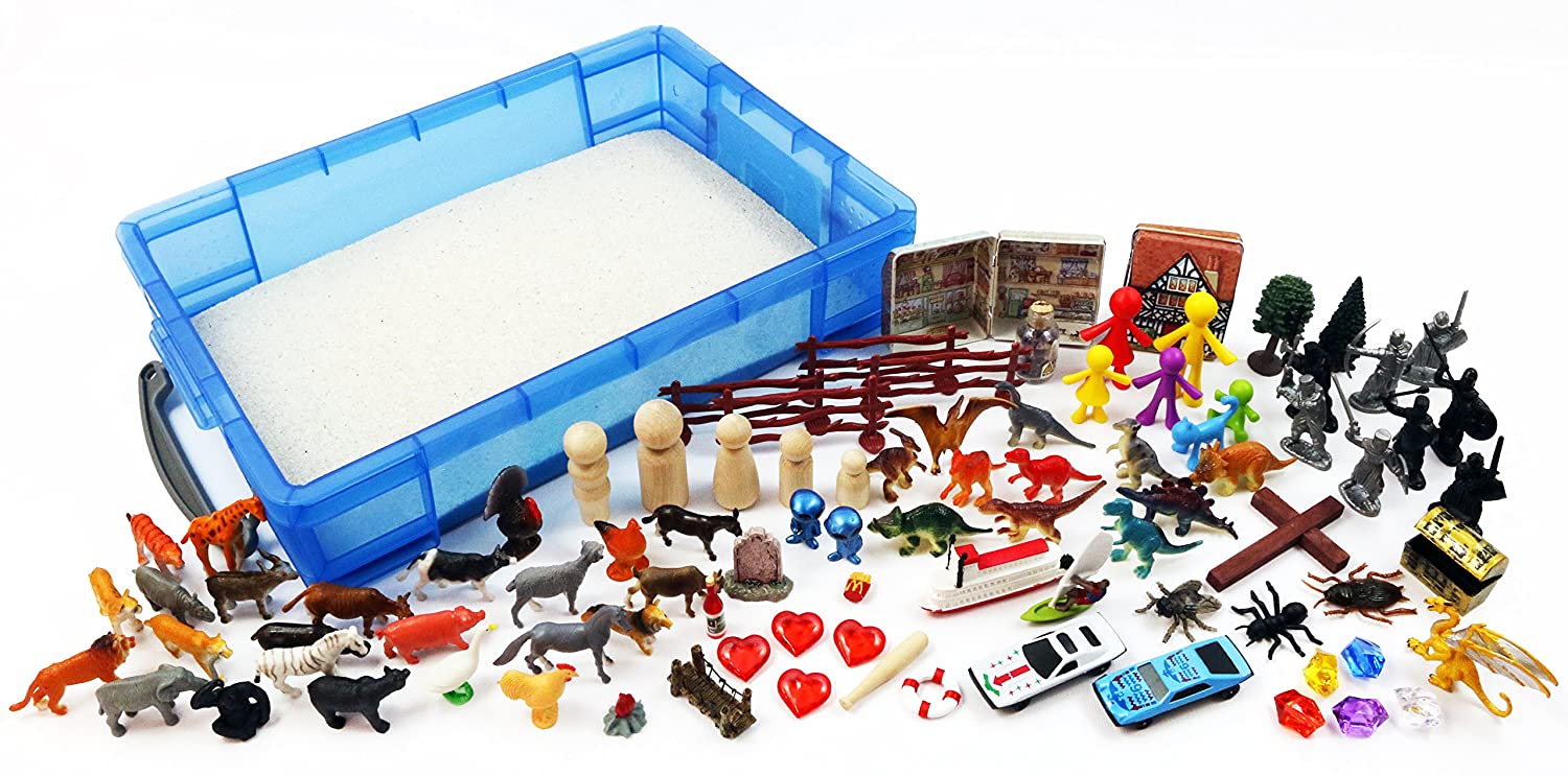 a blue container filled with sand and toys on a table .